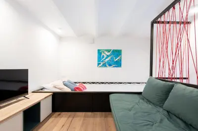 a living room with a couch and a bed at LE CHANCEUX fabuleux duplex en design, pour loisir en couple ou congrès in Cannes