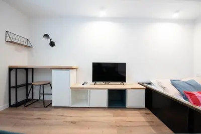 a bedroom with a bed and a desk with a television at LE CHANCEUX fabuleux duplex en design, pour loisir en couple ou congrès in Cannes