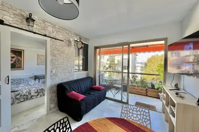 a living room with a couch and a bedroom at Bright 31m2 flowered terrace near Croisette in Cannes