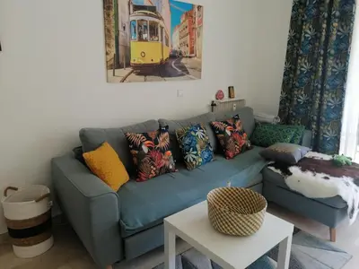 a living room with a blue couch with colorful pillows at Résidence Côte d'Azur Cannes in Cannes