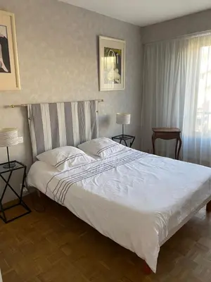 a bedroom with a large white bed and a window at Appartement vue sur mer, proche Croisette in Cannes