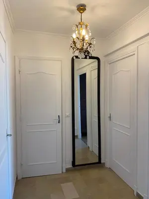a mirror in a hallway with a chandelier at Appartement vue sur mer, proche Croisette in Cannes