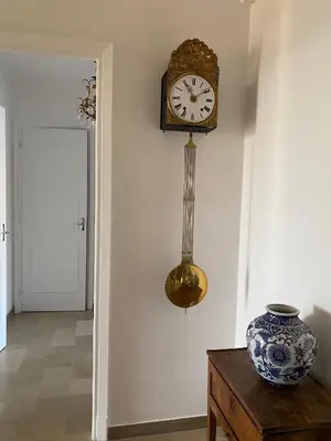 a clock on a wall next to a vase on a table at Appartement vue sur mer, proche Croisette in Cannes