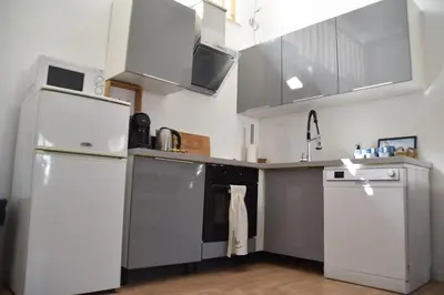 a kitchen with stainless steel appliances and white cabinets at Grand studio-Mezzanine-Centre Cannes in Cannes