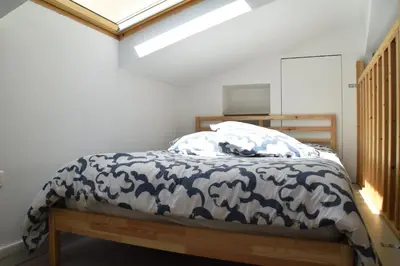 a bedroom with a bed with a blue and white comforter at Grand studio-Mezzanine-Centre Cannes in Cannes