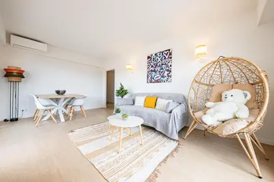 a living room with a rattan chair with a teddy bear at Cannes au Calme à 10 mn à pieds du centre, aperçue mer - Parking gratuit in Cannes