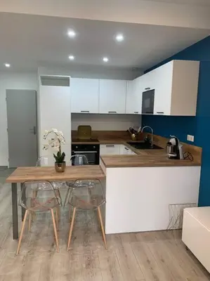 a kitchen with a table and some chairs and a counter at Appartement Etat neuf La Chantalane -proche centre-ville in Cannes
