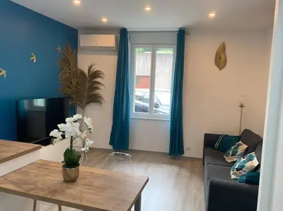 a living room with a couch and a table at Appartement Etat neuf La Chantalane -proche centre-ville in Cannes