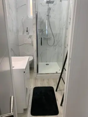 a bathroom with a shower and a black rug at Appartement Etat neuf La Chantalane -proche centre-ville in Cannes