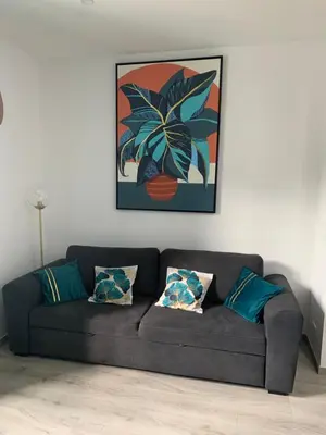 a couch in a living room with a picture on the wall at Appartement Etat neuf La Chantalane -proche centre-ville in Cannes