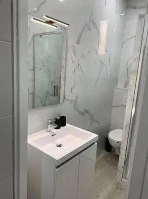 a white bathroom with a sink and a toilet at Appartement Etat neuf La Chantalane -proche centre-ville in Cannes