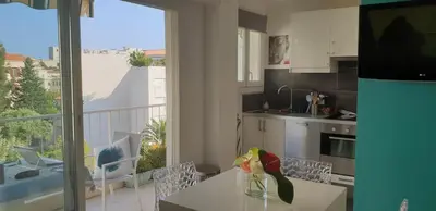 a kitchen with a table and a view of a balcony at Centre et plage tout à pied échappée mer in Cannes