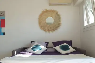 a bedroom with a bed with pillows and a mirror at Centre et plage tout à pied échappée mer in Cannes