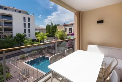 a balcony with a swimming pool and a table and chairs at 2 pièces avec clim, terrasse, piscine, 100m plage in Cannes