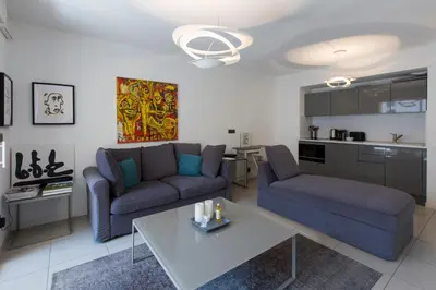 a living room with a couch and a table at 2 pièces avec clim, terrasse, piscine, 100m plage in Cannes