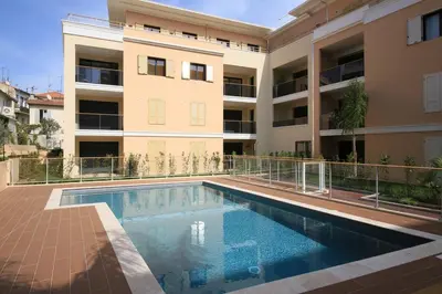an apartment with a swimming pool in front of a building at 2 pièces avec clim, terrasse, piscine, 100m plage in Cannes