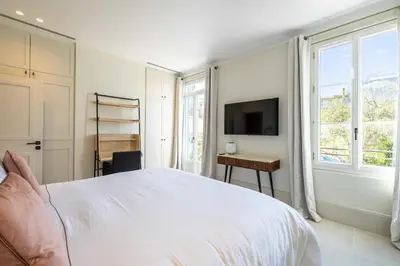 a bedroom with a bed and a desk and a tv at Luxurious Villa with heated pool 5BR-10p - Cannes in Cannes