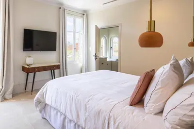 a bedroom with a white bed and a television at Luxurious Villa with heated pool 5BR-10p - Cannes in Cannes