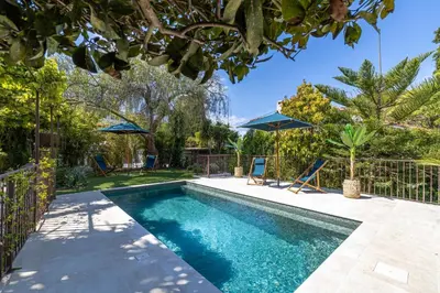 a swimming pool in a yard with chairs and umbrellas at Luxurious Villa with heated pool 5BR-10p - Cannes in Cannes
