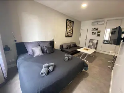 a bedroom with a large bed and a living room at PACA Properties 41H2 - Studio cosy in Cannes
