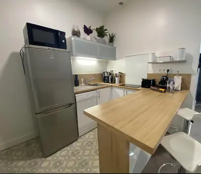 a kitchen with a refrigerator and a wooden table at PACA Properties 41H2 - Studio cosy in Cannes