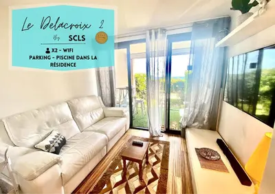 a living room with a white couch in front of a window at Le Delacroix 2 By SCLS Locations in Cannes