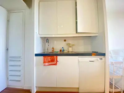 a small kitchen with white cabinets and a refrigerator at Le Delacroix 2 By SCLS Locations in Cannes