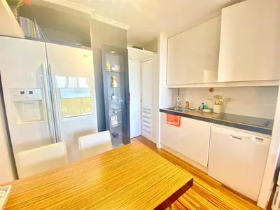 a kitchen with white cabinets and a wooden floor at Le Delacroix 2 By SCLS Locations in Cannes