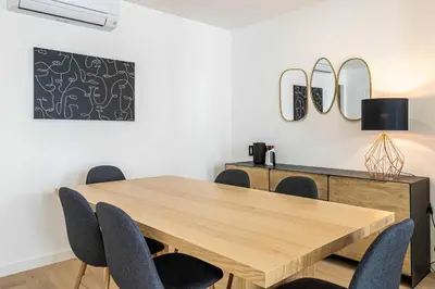 a dining room with a wooden table and chairs at Superb 90m2 apartment in the heart of Cannes in Cannes