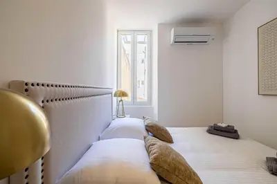 two twin beds in a room with a window at Superb 90m2 apartment in the heart of Cannes in Cannes