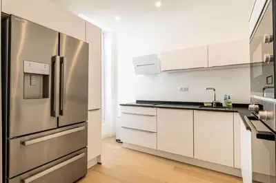 a kitchen with a stainless steel refrigerator and white cabinets at Superb 90m2 apartment in the heart of Cannes in Cannes