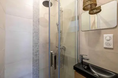a shower with a glass door next to a sink at Superb 90m2 apartment in the heart of Cannes in Cannes