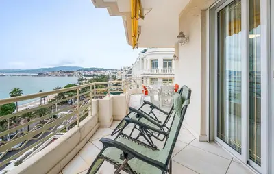 a balcony with chairs and a view of the water at 2 Bedroom Cozy Apartment In Cannes in Cannes