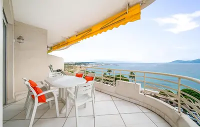a balcony with a table and chairs and the ocean at 2 Bedroom Cozy Apartment In Cannes in Cannes