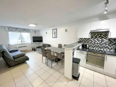 a kitchen and living room with a table and chairs at Modern one bedroom apartment in Cannes in Cannes