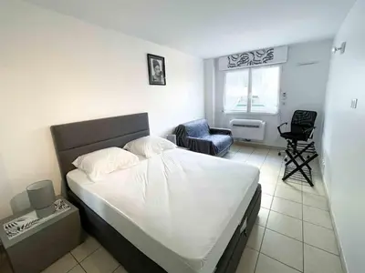 a small bedroom with a bed and a chair at Modern one bedroom apartment in Cannes in Cannes