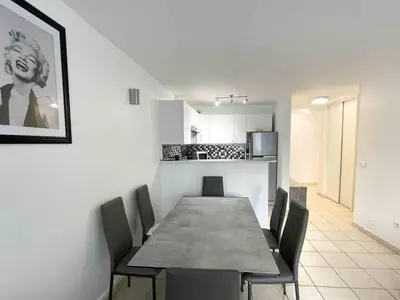 a dining room with a table and chairs and a kitchen at Modern one bedroom apartment in Cannes in Cannes