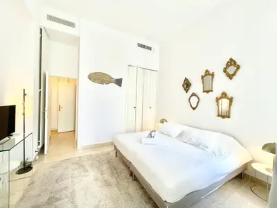 a white bedroom with a bed and a tv at Marina Luxury 3 bedroom by Welcome to Cannes in Cannes