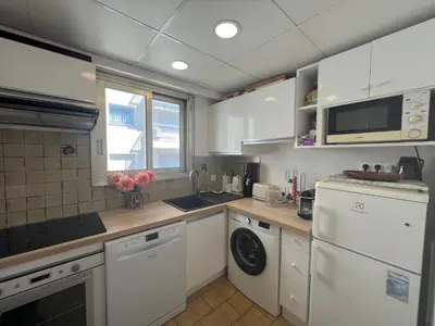 a kitchen with white cabinets and a washer and dryer at Alexandra apartment by Welcome to Cannes in Cannes