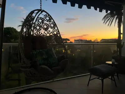 a hanging chair on a balcony with a sunset at Parc Montfleury in Cannes