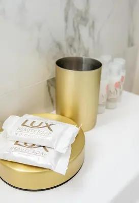 a gold plate with a bag of toilet paper and a cup at Luxueux 3p. Art Deco + Parking in Cannes