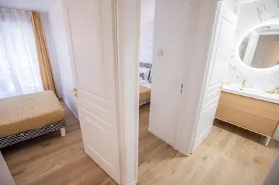 a white room with a bed and a mirror at Luxueux 3p. Art Deco + Parking in Cannes