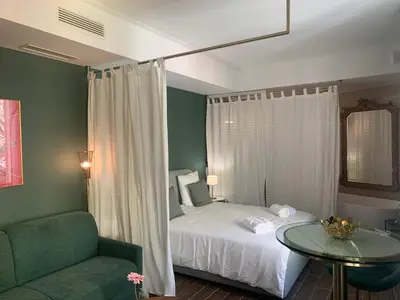 a bedroom with a bed and a table and a chair at Villa les fougeres suite festival jardin garage in Cannes
