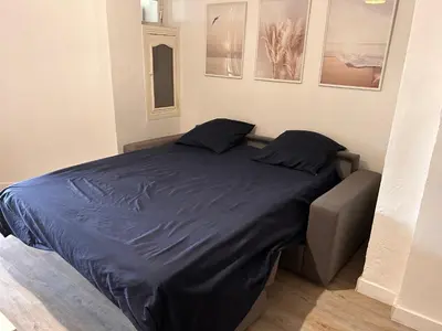 a bed in a room with a blue comforter at CANNES RIVAGE bord de mer in Cannes