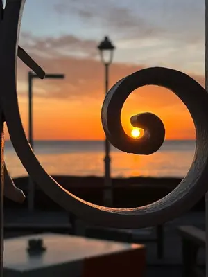 a view of a sunset through a metal railing at CANNES RIVAGE bord de mer in Cannes