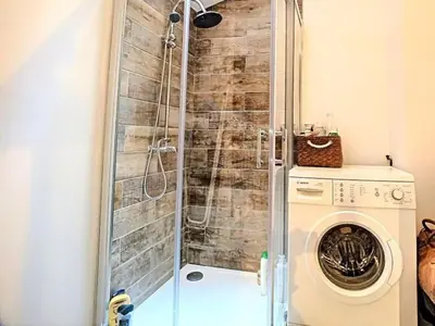 a shower in a bathroom with a washing machine at CANNES RIVAGE bord de mer in Cannes