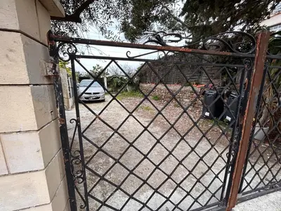 an iron gate with a car parked in a driveway at CANNES RIVAGE bord de mer in Cannes