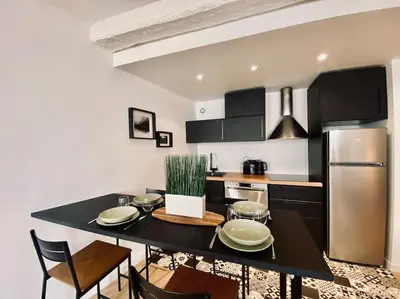 a kitchen with a black table and a stainless steel refrigerator at Appartement Centre ville, Cannes le Suquet in Cannes