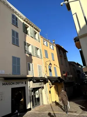 a person walking down a street in front of a building at Appartement Centre ville, Cannes le Suquet in Cannes