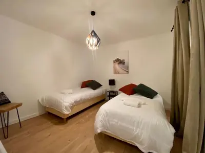 a bedroom with two beds and a pendant light at Appartement Centre ville, Cannes le Suquet in Cannes